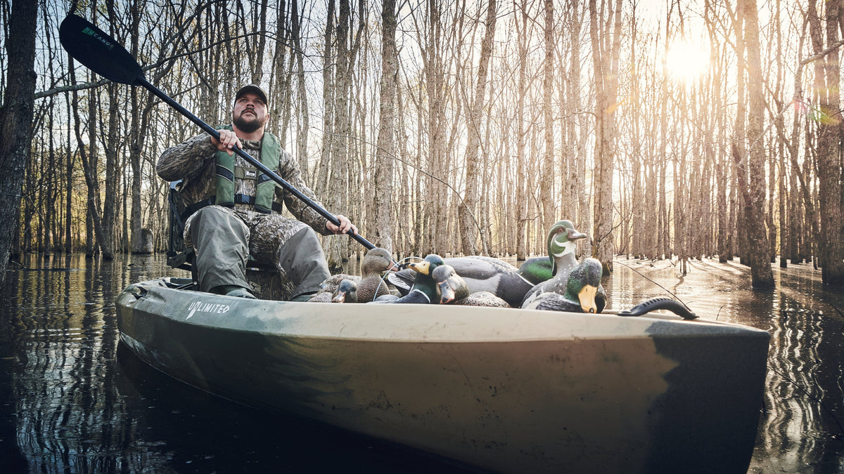 Hunter paddling a NuCanoe kayak loaded with duck decoys